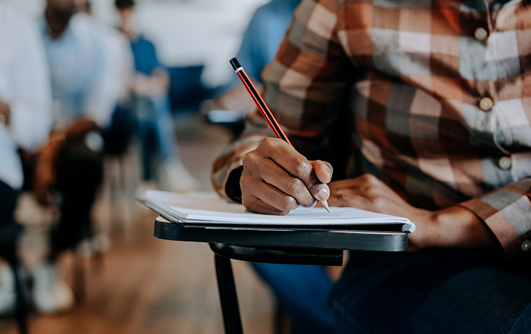 Un étudiant en classe assis avec papier et crayon