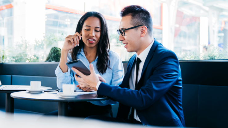 Conseiller montrant des informations à sa cliente à partir d'un téléphone intelligent