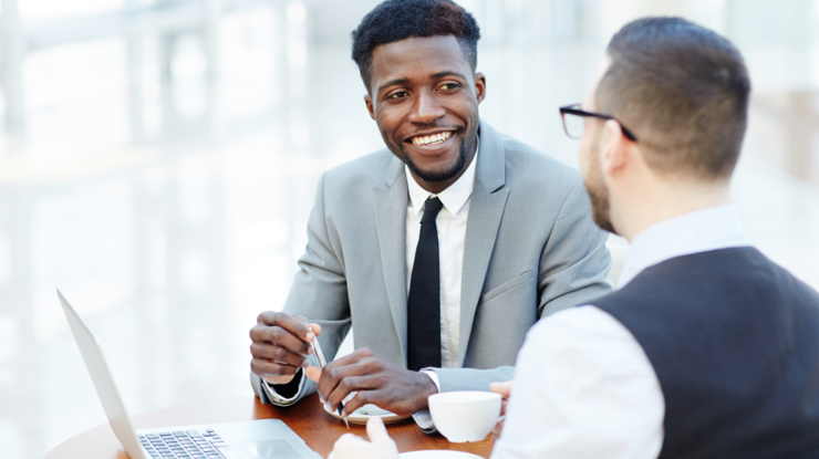 Jeune conseiller avec son client en pleine discussion, assis dans un café